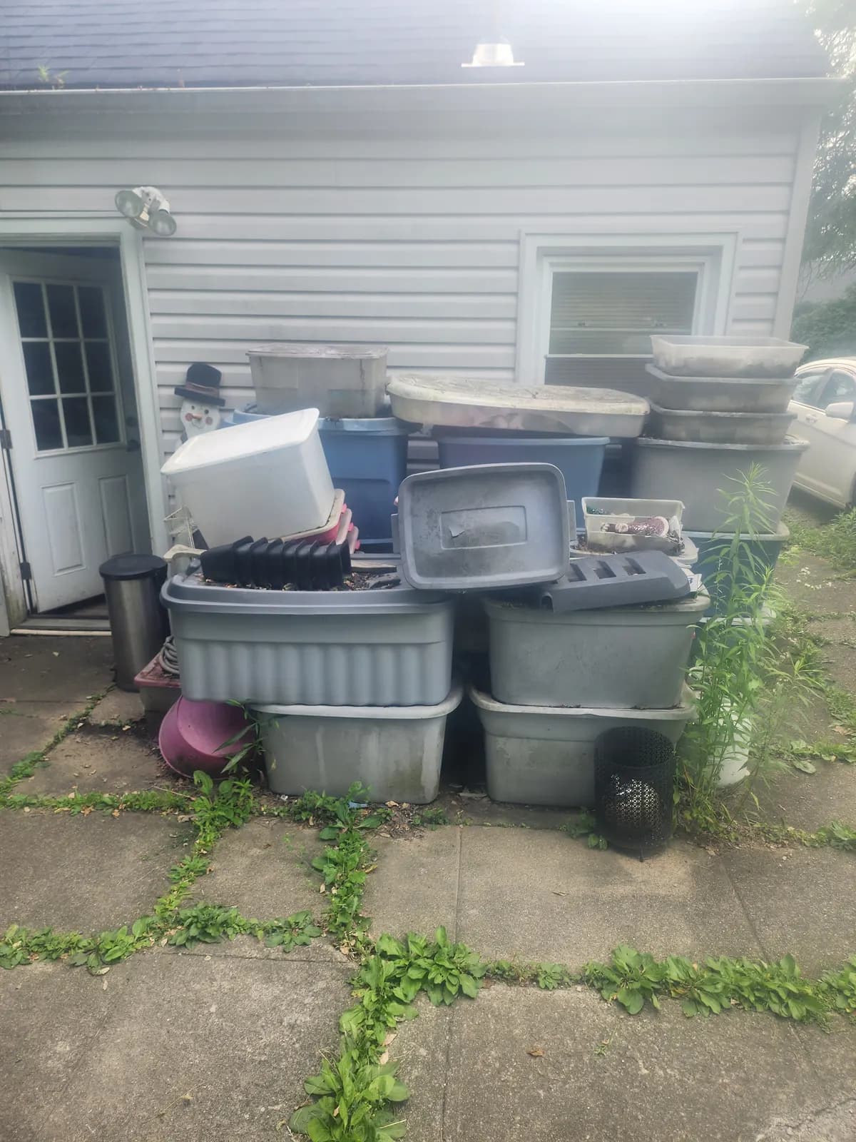 Junk removal — bins and planters stacked for pickup